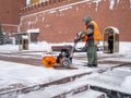 A utility worker cleans snow with a snowplow at the grave of the Unknown Soldier in the Kremlin during a snowfall Royalty Free Stock Photo