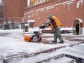 A utility worker cleans snow with a snowplow at the grave of the Unknown Soldier in the Kremlin during a snowfall Royalty Free Stock Photo