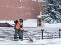 A utility worker cleans snow next to a soldier at a post near the Kremlin wall Royalty Free Stock Photo