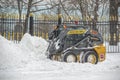 Moscow, Russia, February 13, 2021: Yellow tractor clears snow-covered roads on a city street Royalty Free Stock Photo