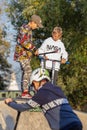 Group of teenager boys skateboarding and scooter riding in the park.