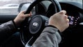 Moscow, Russia - January 2, 2020: Black steering wheel of a car with the KIA logo close-up. Hands of the driver of a South Korean