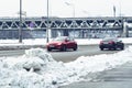 Fast moving red Opel Astra J car with motion blur effect. Urban winter landscape with snow drifts along the road Royalty Free Stock Photo