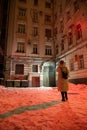 Girl stands in the middle of an old Moscow courtyard on a cold winter night