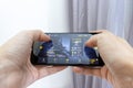 MOSCOW, RUSSIA - JANUARY 08, 2018: Hands holding a smartphone with online multyplayer shooter game Sniper Arena. Mobile gaming and