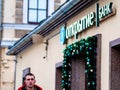 Moscow, Russia - January 17, 2020: Man near Otkritie Bank sign above the entrance. Christmas garland of Christmas toys and fir