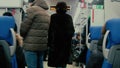 A young woman is walking along a train carriage.