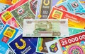 Moscow, Russia, July 2020: Close up of various Russian lottery tickets with banknote of one hundred rubbles in the middle. Russian