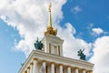 Moscow, Russia - July 22, 2019: Decorated roof with spire of pavilion USSR on VDNH in Moscow against blue sky with white clouds at