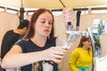 A barman girl pours beer into a plastic glass