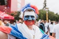 MOSCOW, RUSSIA - JULY 2018: Football fan face painted in the colors of the Russian flag and hat in the fan zone during the World C