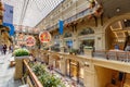 Moscow, Russia - July 28, 2019: Glass showcases of boutiques in GUM State Department Store against flowers in flowerbeds.