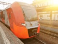 Modern high speed red commuter train at railway platform