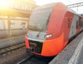 Modern high speed red commuter train at railway platform