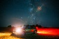 Night Starry Sky With Glowing Stars Above Renault Duster SUV Car In Countryside Landscape. Milky Way Galaxy And Rural