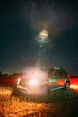 Night Starry Sky With Glowing Stars Above Renault Duster SUV Car In Countryside Landscape. Milky Way Galaxy And Rural