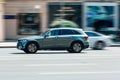 Retired elderly man driving silver Mercedes GLC car on city street. Senior driver driving his modern SUV car Royalty Free Stock Photo