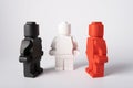 Moscow, Russia - July 26, 2022. Three lego figures. The white figure is located between the red and black