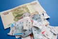 Moscow, Russia, July 2020: Torn lottery tickets with numbers with banknote of one hundred rubles on blue background. Russian Lotto