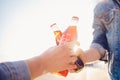 Moscow, Russia - June 27, 2019: clink drink Coca Cola glass bottle in hands, sunset.