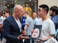 Football fan with a portrait of the coach of the Russian national team gives interview to the TV reporter on Nikolskaya street in