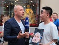 Football fan with a portrait of the coach of the Russian national team gives interview to the TV reporter on Nikolskaya street in