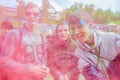 Moscow, Russia - June 3, 2017: Group portrait of joyfully smiling three teenage boys in cloud of pink dust at Holi