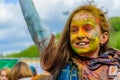 Moscow, Russia - June 3, 2017: Little girl with joyful smile and multi-colored face on summer holiday Holi