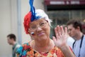 Old russian woman sport fan with russian flag on her cheek welcoming hand sign in Moscow