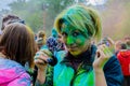 Moscow, Russia - June 3, 2017: Portrait of blonde woman, strewn with green paint after Holi-expression at festival