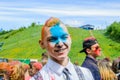 Moscow, Russia - June 3, 2017: Portrait of a smiling european teenage guy in a white shirt and face in blue paint