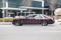 Purple premium class sedan Rolls-Royce ghost 2nd generation is driving on the city street