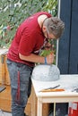 Stonemason processes a spherical stone with a chisel and a hammer at the festival `Times and epochs` in Kuznetsk bridge in Moscow