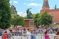 Moscow, Russia - June 21, 2018: Tourists walk on Red square near monument to Minin and Pozharsky against walls and towers of