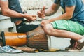 Moscow, Russia - JUNE 1, 2014: Two young men set up and prepare the ehnic percussion musical instrument jembe Royalty Free Stock Photo