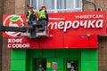 MOSCOW, RUSSIA - June 11, 2018: Workers dismantle a sign at the popular food store Pyaterochka.