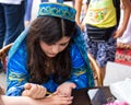 The girl master puts a temporary henna tattoo on the hand of a young woman