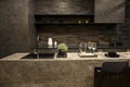 MOSCOW / RUSSIA - 04/03/2019 luxurious spacious modern kitchen island in black grey brown stone marble tones, a sink, a Royalty Free Stock Photo