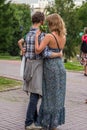 A man hugging his wife in the park. Feelings and emotions of a couple in love. Happy people of the world.