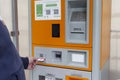 Moscow, Russia, 05/15/2020: A man inserts a ticket into the parking meter on the street. Close-up. Paid parking