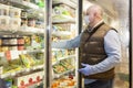 Moscow, Russia, 09/04/2020: A man in a medical mask and gloves chooses frozen foods in a supermarket. Precautions during the