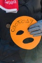 Activist holds the mask, the symbol of Riot on picket to f
