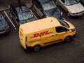Moscow, Russia - March 11, 2020: DHL Deutsche Post courier in yellow-red uniform near minivan with company logos. DHL