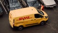 Moscow, Russia - March 11, 2020: DHL Deutsche Post courier in yellow-red uniform near minivan with company logos. DHL