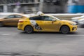 Dirty yellow Yandex taxi cab on the Moscow streets in motion. Taxi ride in muddy slushy weather