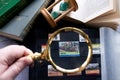 Hobby - stamp collecting. 60 cent stamp with locomotiv through a golden magnifying glass. Old books,