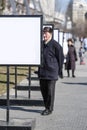 Oldster stands near the advertising stand