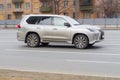 Silver SUV car Lexus LX 570 is driven at empty city asphalt road