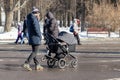 MOSCOW, RUSSIA - MARCH 02, 2019: Single man with baby stroller, carriage walks in the winter park