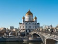 Moscow, Russia - March 01, 2022: View of the Cathedral of Christ the Savior and the Patriarchal pedestrian bridge against the blue Royalty Free Stock Photo